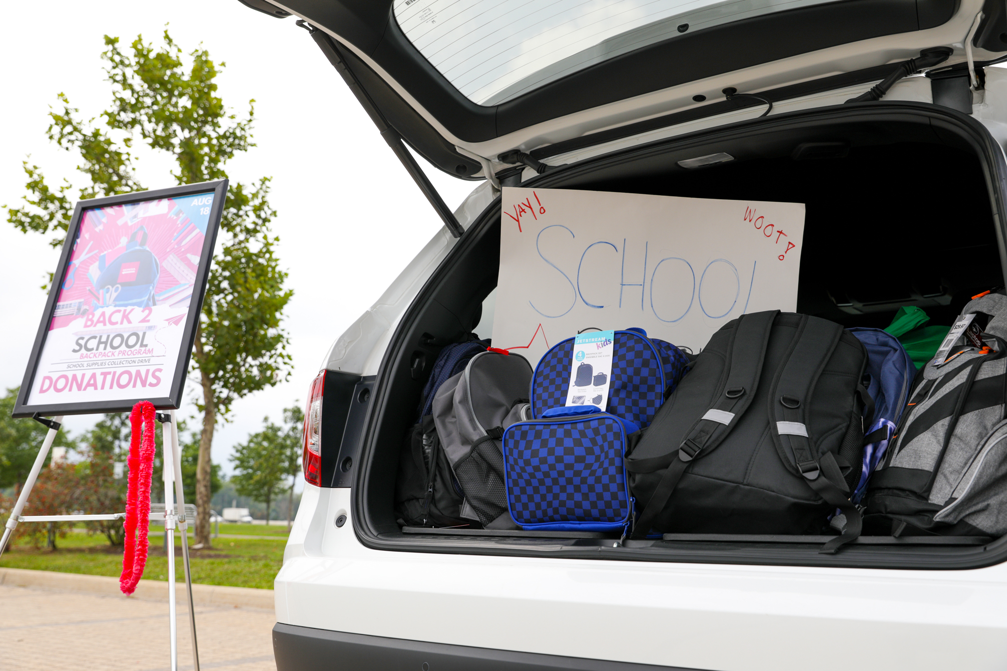 Open trunk of vehicle, filled with backpacks.